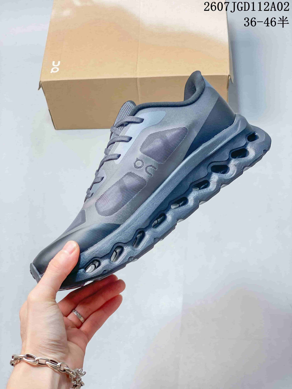 Side view of the gray sneaker showing layered upper panels and sculpted sole.