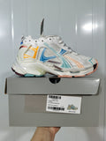 Balenciaga Runner sneaker in white with yellow, blue, teal, and burgundy accents displayed on its labeled shoe box.