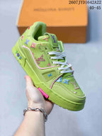 Angled side view of the green Louis Vuitton Trainer sneaker showing the white laces, patterned upper, layered midsole, and pink outsole accent.