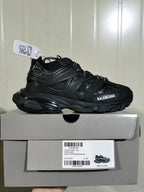 Side view of a black Balenciaga Track Sock sneaker resting on its box, with the product label visible below.