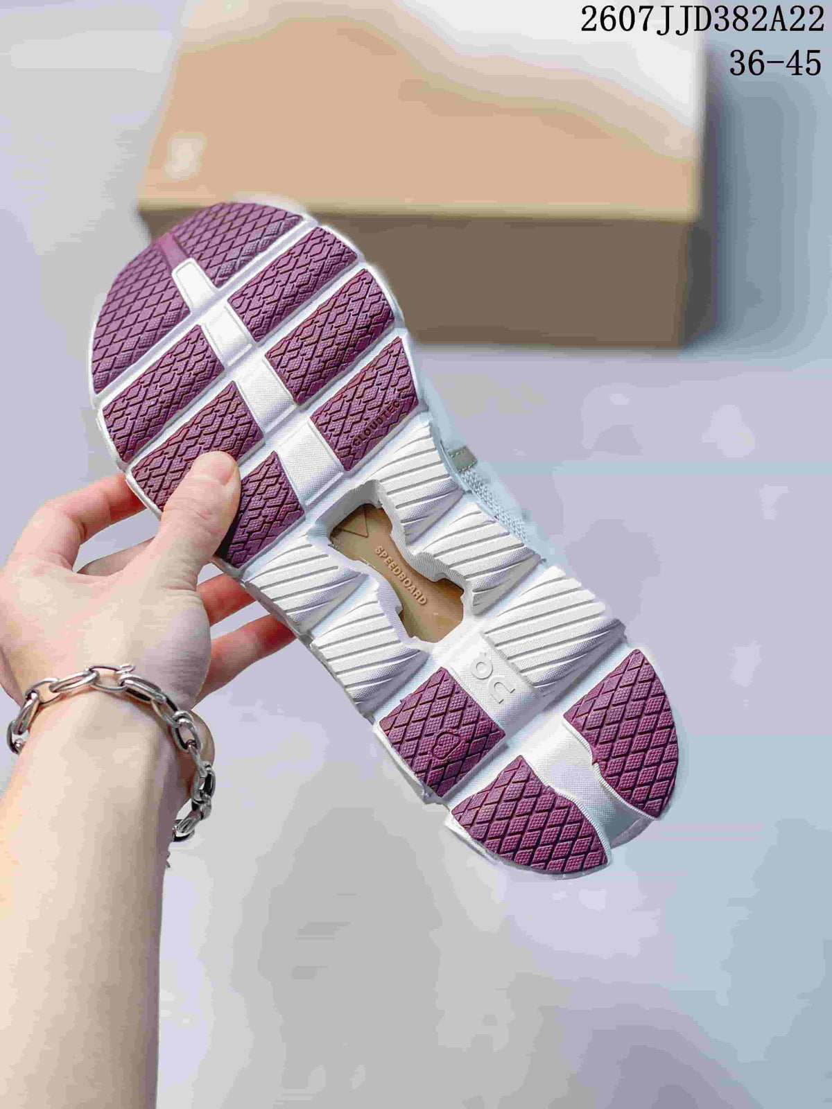 Underside view of the sneaker showing the segmented white outsole, burgundy traction sections, and open cushioning cavities.