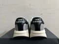 Rear view of gray and white New Balance U370 sneakers with black heel panels.