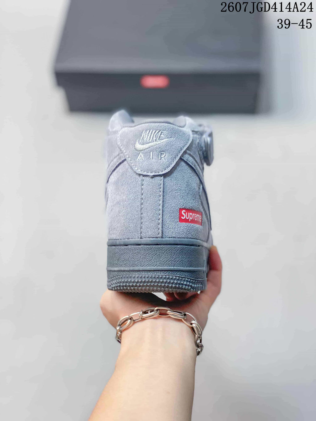 Rear view of the gray high-top sneaker showing the padded collar, Nike Air tongue label, and red rectangular heel label.