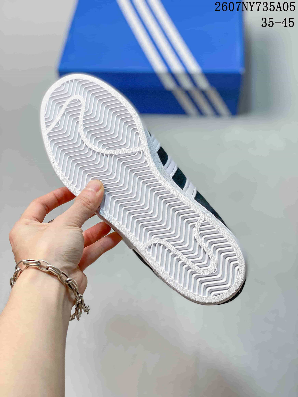 Close view of the white rubber outsole with a repeating herringbone-style tread pattern.
