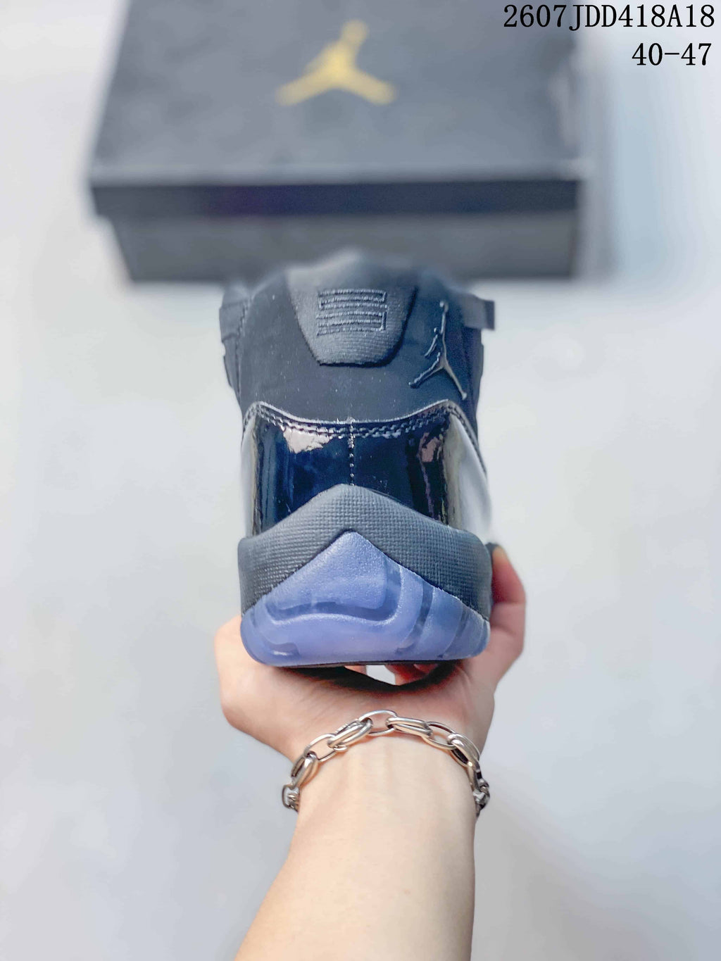 Rear view of the high-top sneaker showing the padded collar, glossy heel overlay and translucent outsole.