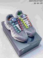 Pair of grey Nike Air Max 95 sneakers with multicolor lace accents displayed on a Nike shoe box.