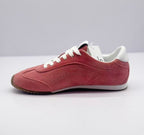 Opposite side view of the pink low-top sneakers with white collar and heel accents.