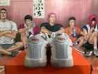 Rear view of white and red Nike basketball shoes showing heel panels and perforations.