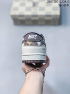 Rear view showing the white heel, dark collar, brown outsole edge, and branded tongue detail.