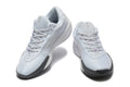 Pair of pale grey and white Nike low-top tennis shoes with purple accents, shown from the front