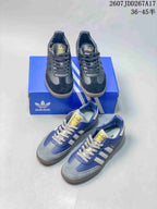 Black and blue adidas Samba sneakers arranged with a blue adidas shoebox.