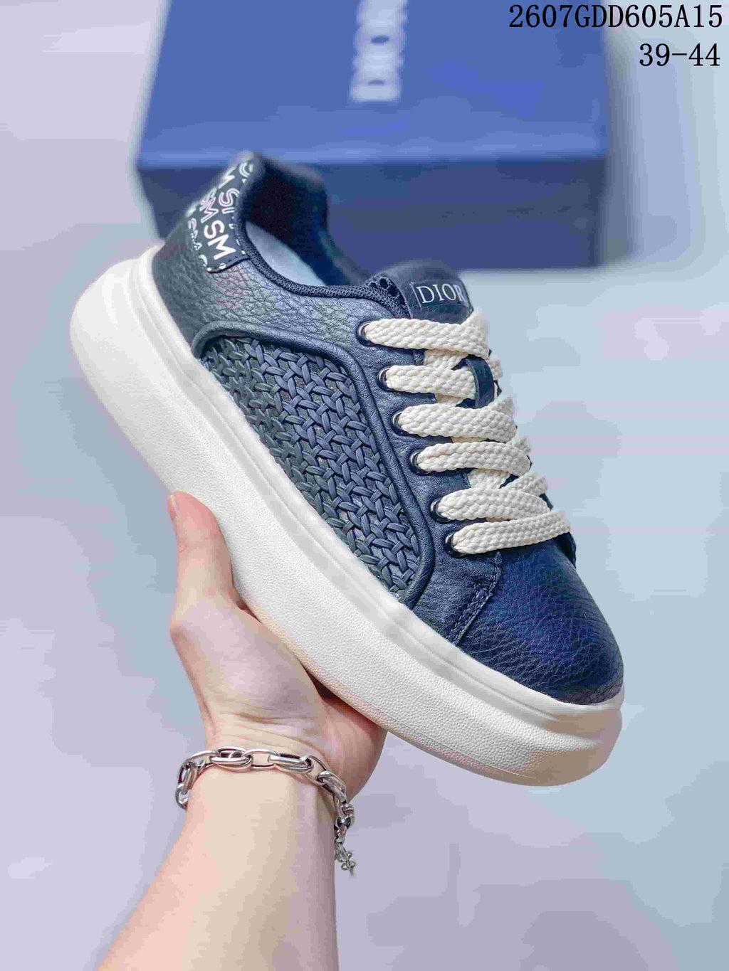 Angled side view of the navy and white sneaker showing the woven side panel, branded heel detail and cream outsole.