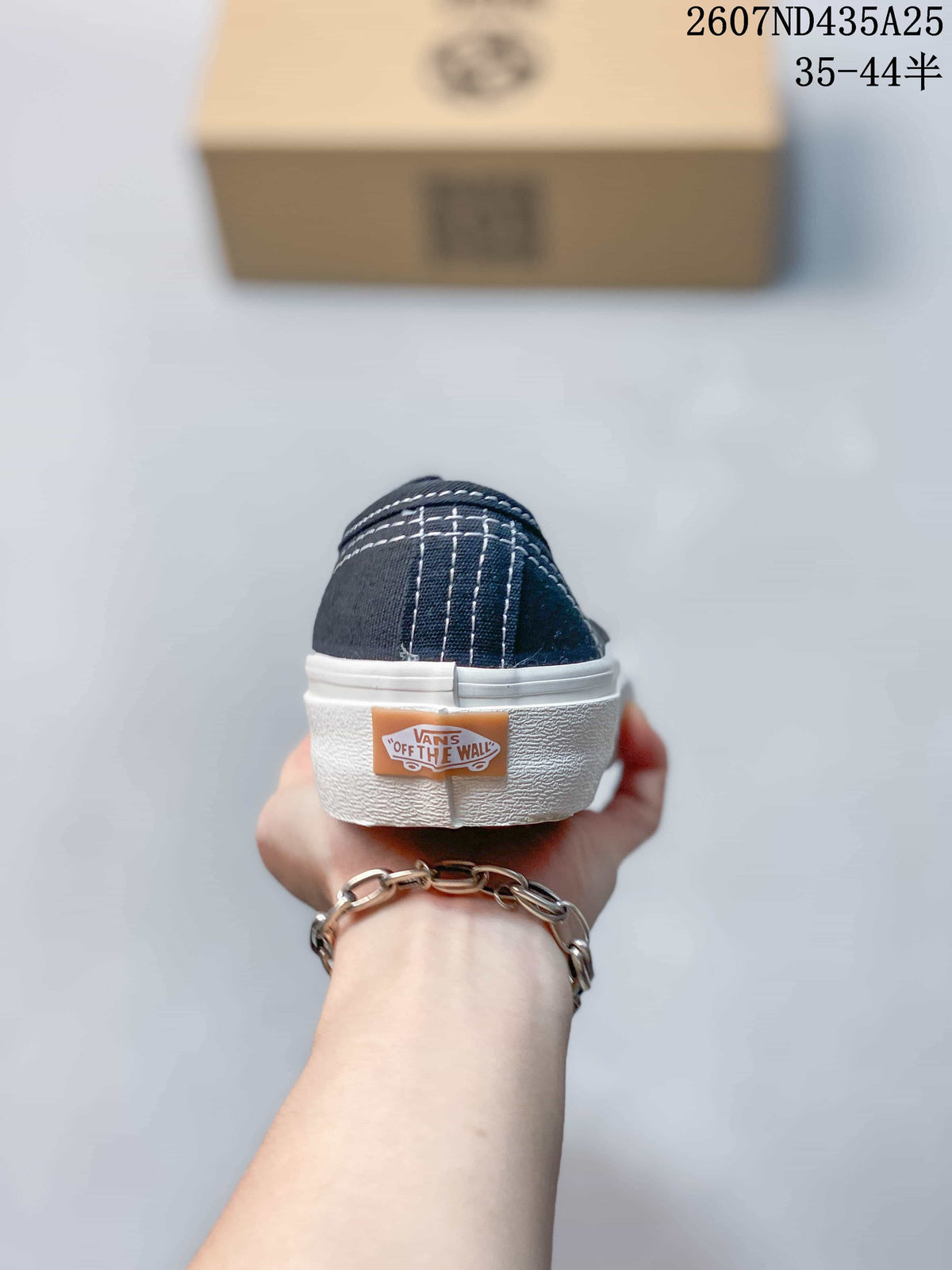 Rear view of the navy sneaker showing white heel stitching, a heel logo patch, and the white rubber sole.