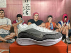 Side view of a white, grey, and black sneaker with a side Swoosh