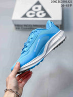 Side view of the blue Nike ACG Pegasus Trail sneaker showing the textured upper, white midsole, and dark outsole.