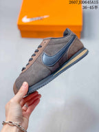 Side view of the sneaker showing the contrasting dark Swoosh, brown upper, lace-up construction, and layered sole.