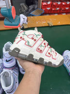 Hand-held view of the cherry-print sneaker in a workshop setting