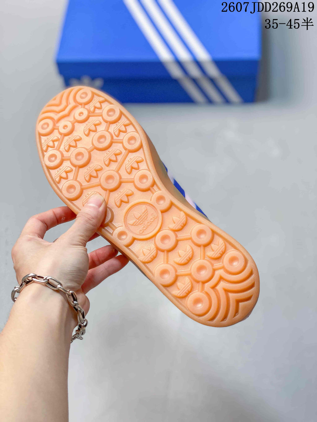 Close-up of the gum-colored outsole showing its circular and trefoil-patterned tread.
