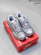Pair of silver and white Nike P-6000 sneakers displayed on a red shoebox.