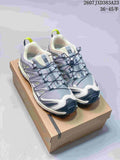 Pair of Salomon XA Pro 3D sneakers in sand gray with contrasting accents, shown on a Salomon shoe box.