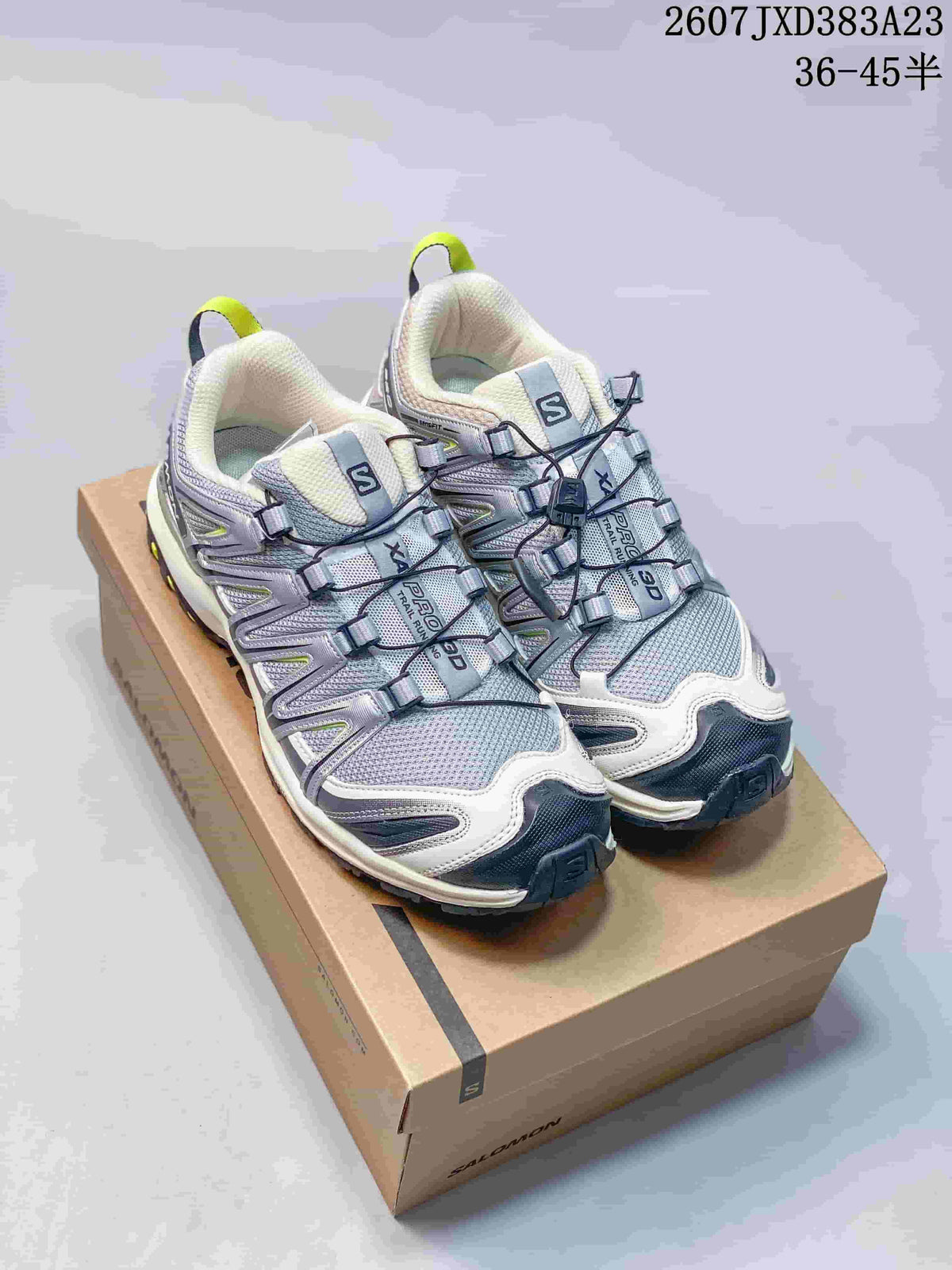 Pair of Salomon XA Pro 3D sneakers in sand gray with contrasting accents, shown on a Salomon shoe box.