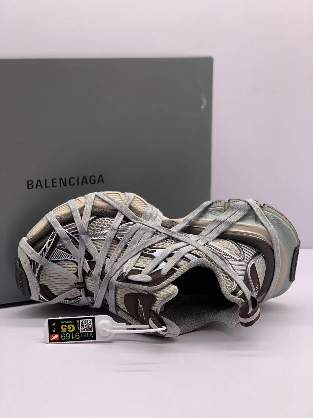 Top-side view of one sneaker showing the layered lace construction, padded collar, and attached product tag.