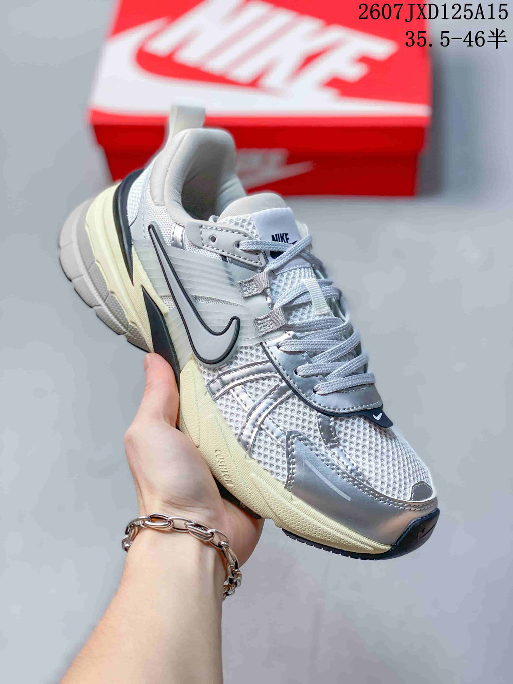 Side view of a silver and white Nike V2K sneaker highlighting the layered upper and sculpted outsole.