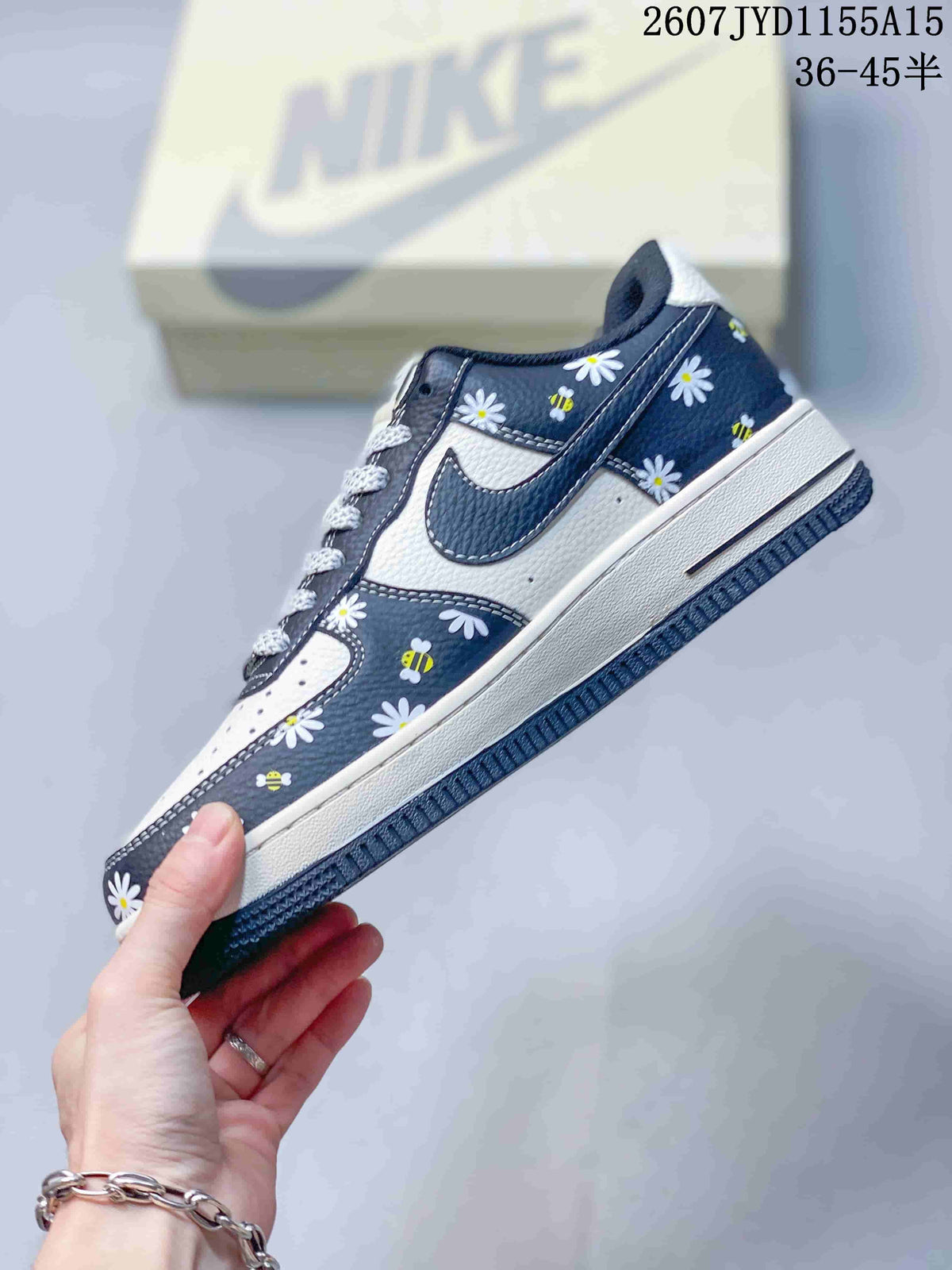 Side profile showing the navy Swoosh, white panels, floral and bee graphics, and layered sole.