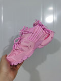 Close-up view of a pink Balenciaga Track sneaker showing its layered upper, multiple laces, mesh panels and chunky outsole.