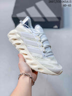 Angled side view of the white Adidas sneaker showing the layered side branding, textile upper, and sculpted cushioned sole.