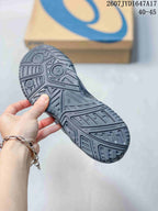 Close view of the patterned outsole on a dark ASICS tennis shoe, with an ASICS box in the background; image text shows 2607JYD1647A17 and 40–45.