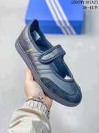 Close-up of a black Samba Jane sneaker with tonal stripes, a hook-and-loop strap and textured toe panel.