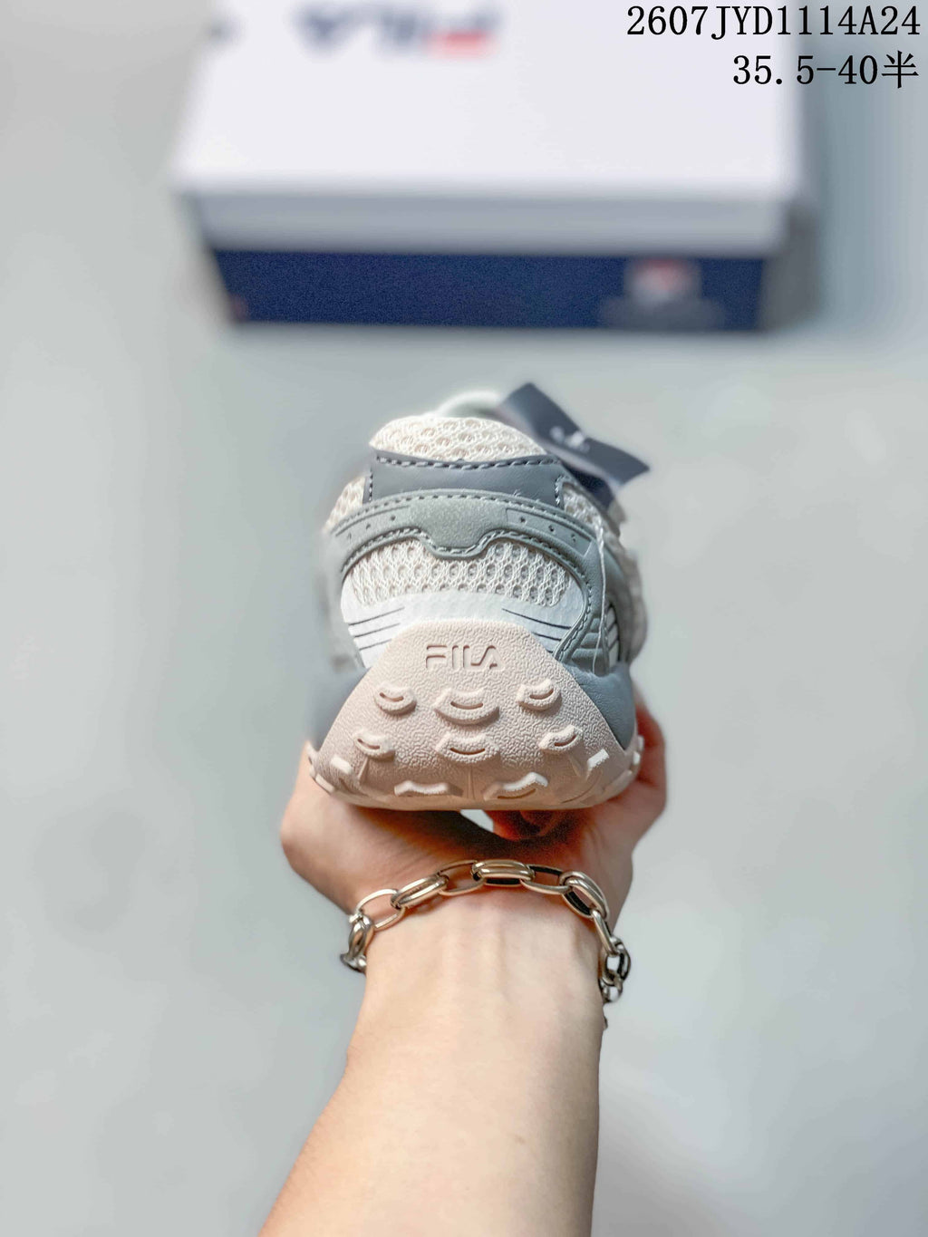 Rear view of the sneaker showing the padded heel, mesh panel, FILA branding, and textured outsole.