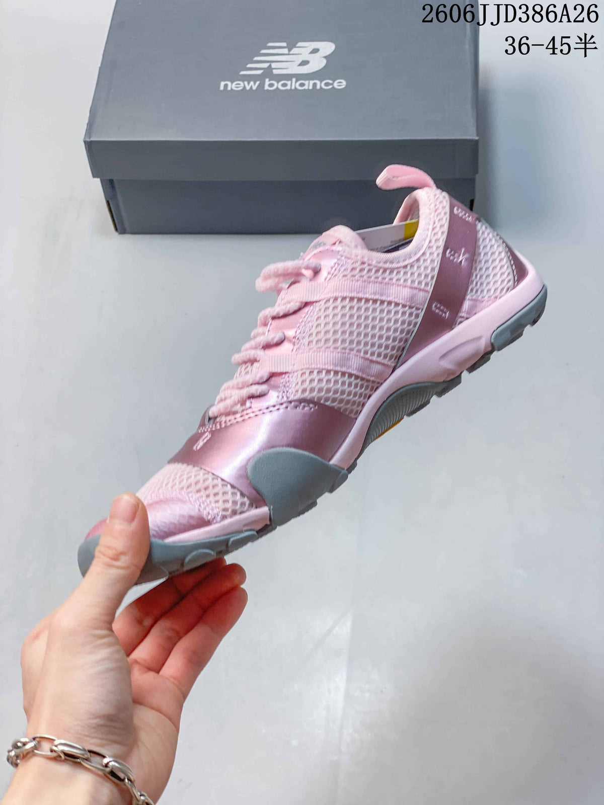 Side view of the pink low-top sneaker showing the mesh-textured upper, laces, and gray outsole.