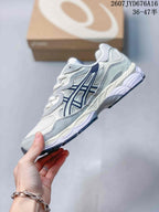 Side profile of the white, grey and navy ASICS GEL-NYC sneaker with layered panels, mesh sections and a segmented sole.