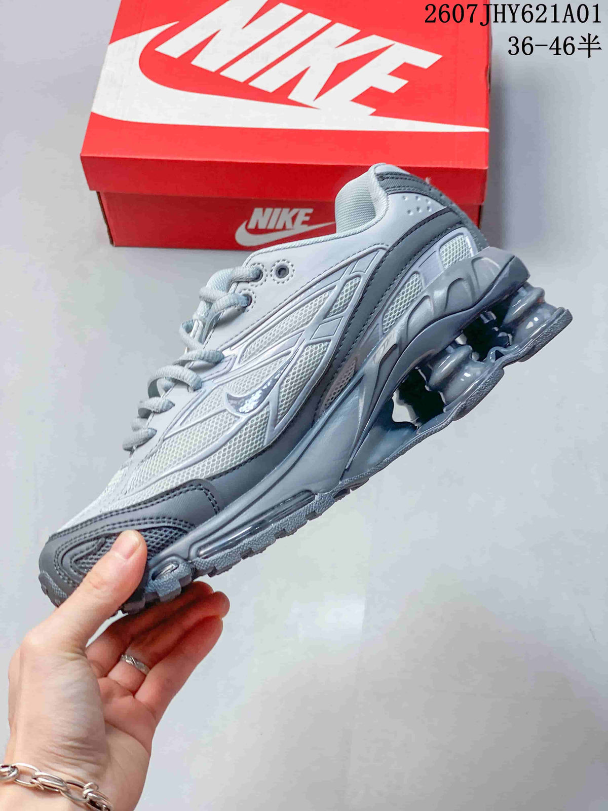 Side view of a silver and gray sneaker with mesh panels and heel columns