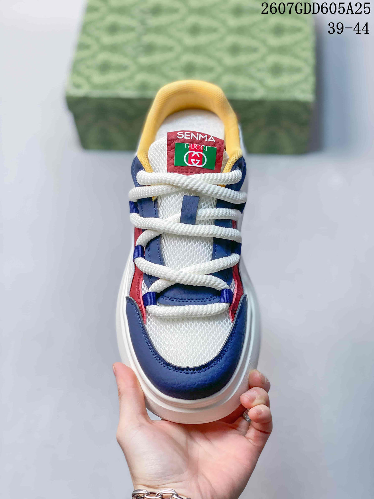 Top view showing white rope-style laces, navy and red overlays, yellow collar lining, and the Gucci and Senma tongue labels.