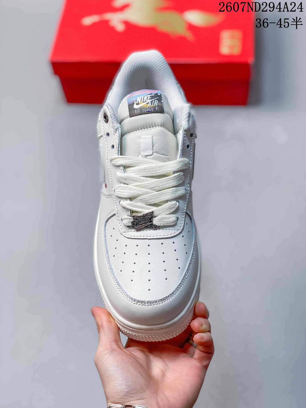 Top view of the white sneaker showing the perforated toe box, white laces, padded tongue and lace accessory.