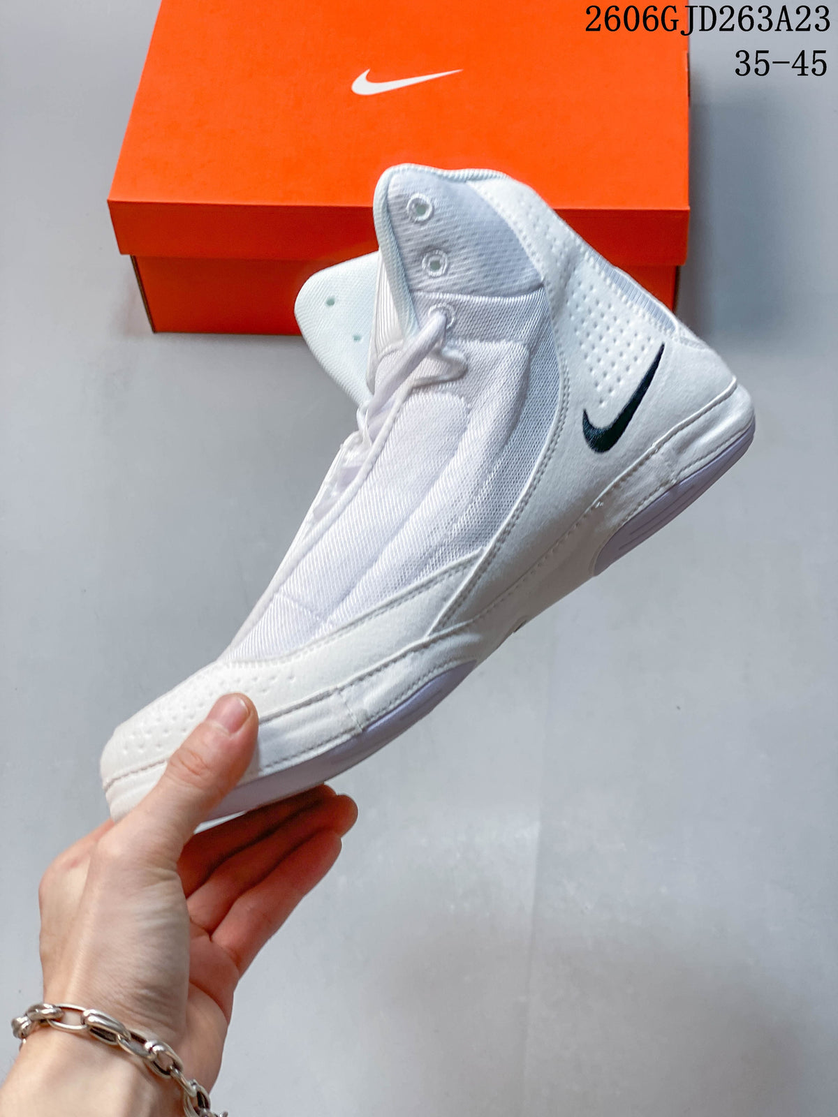 Side view of a white Nike Inflict 4 wrestling shoe with a dark Swoosh.