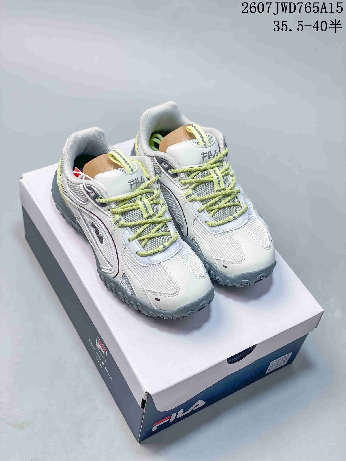 Pair of white and lime FILA Pebble low-top sneakers displayed on a shoebox