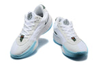 Pair of white Nike basketball shoes with dark green details, light blue soles, and speckled midsoles, shown from the front.