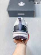 Rear view of the shoe showing the pull tab, dark heel panel, DESCENTE branding, and layered outsole.