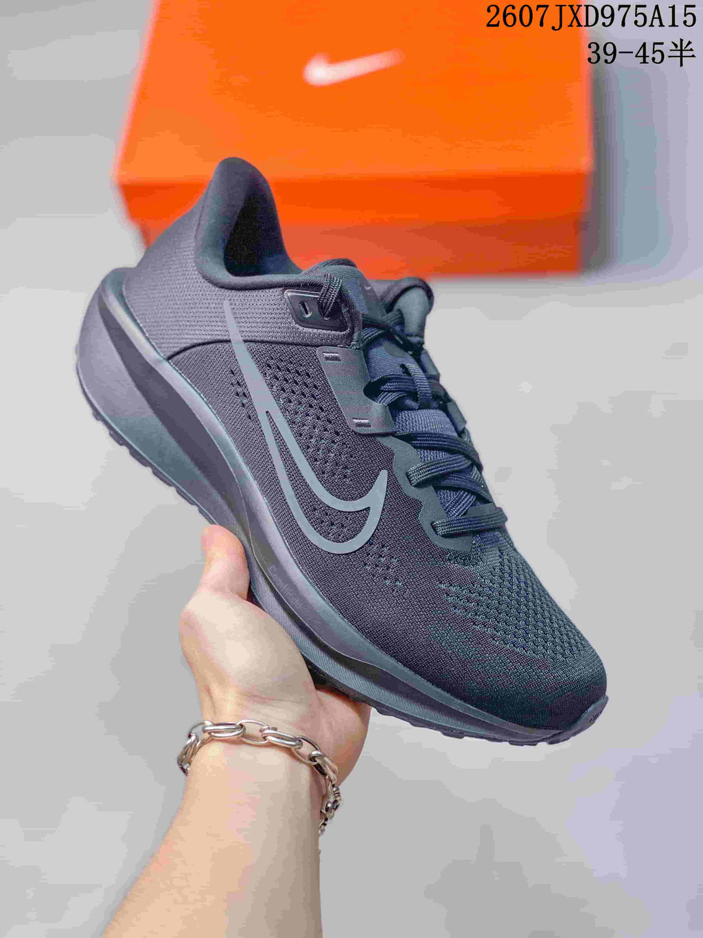 Close-up of a dark charcoal Nike Quest 6 sneaker with tonal detailing and a textured outsole.