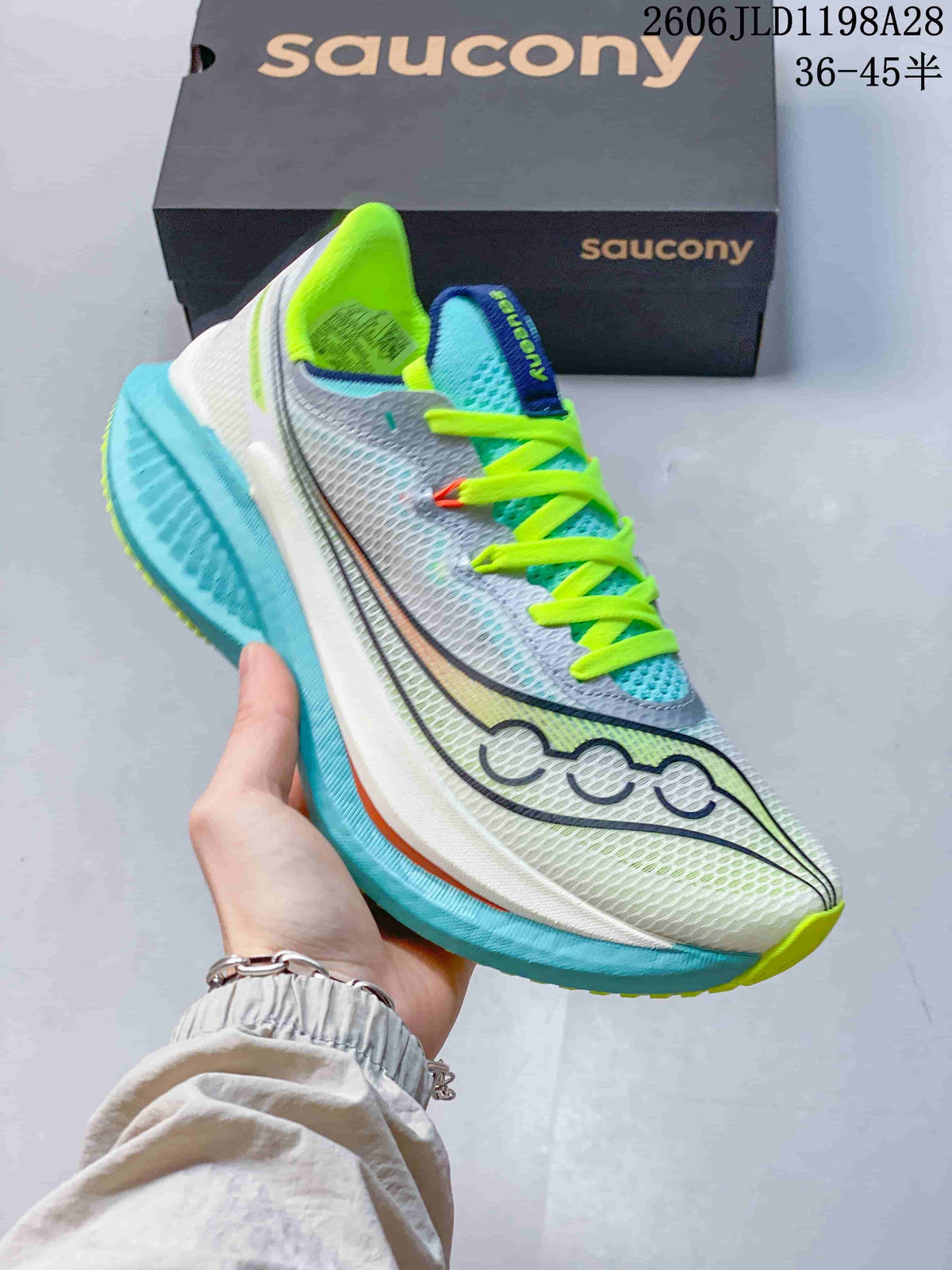 Angled side view of the Saucony running shoe with aqua sole and white upper