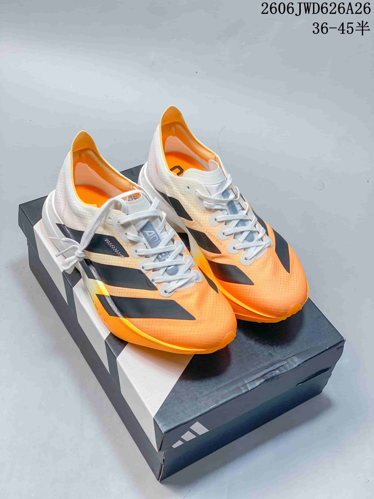 Pair of orange running shoes with black and white details displayed on a shoebox.