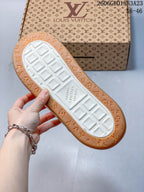 Underside of a sneaker showing a white tread center and gum-colored patterned outsole edge.
