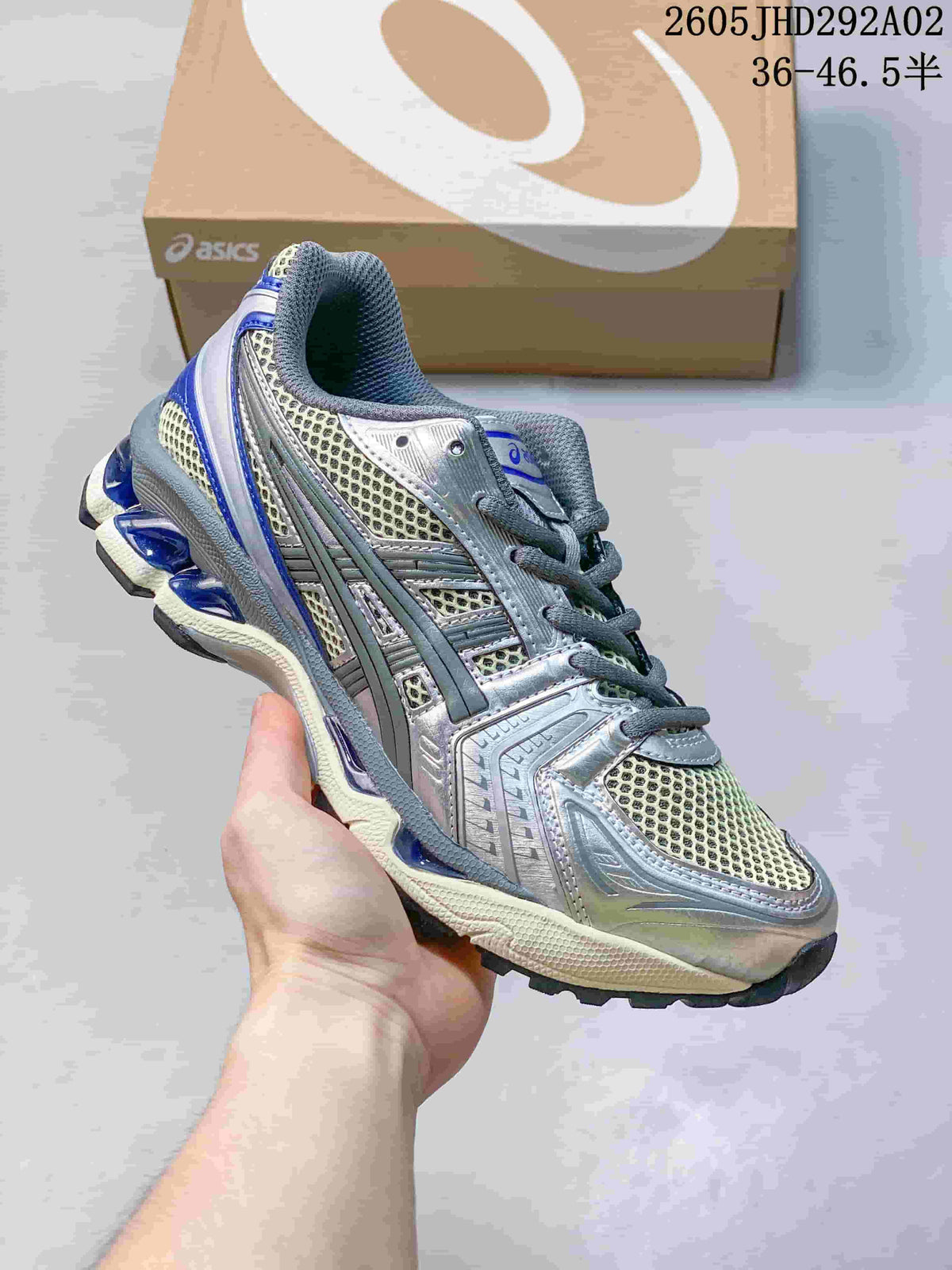 ASICS GEL-KAYANO 14 sneaker in silver, cream, and blue, shown from the front-side angle.