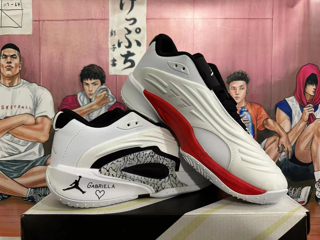 Two white Jordan Luka basketball shoes, showing the patterned side panel and red outsole detail.