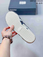 Underside view of an Onitsuka Tiger sneaker showing the textured white rubber outsole and central brand panel.