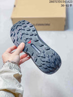 Close view of the Salomon Genesis outsole showing a pronounced lugged tread pattern and Salomon branding.